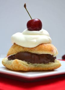 Rich chocolate ganache layered between flaky Puff Pastry and topped with homemade whipped cream. Absolute dessert perfection | www.craftycookingmama.com